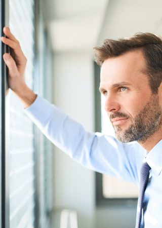 businessman looking through the window at office